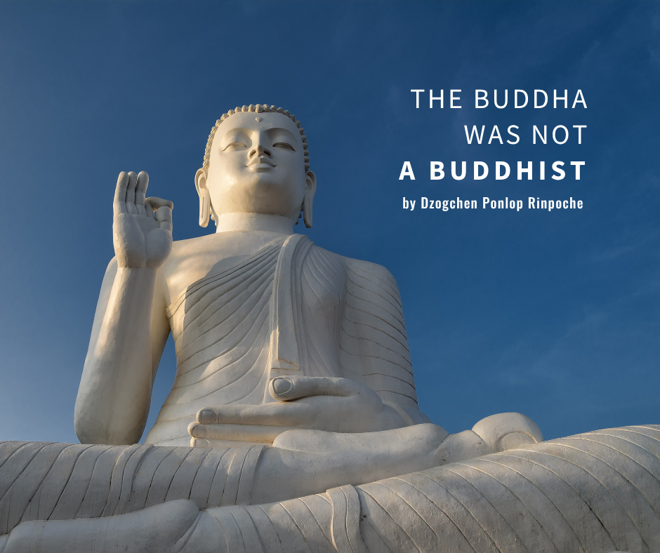 White marble Buddha statue wearing robes with right hand in vitarka mudra and seated in vajra posture, crosslegged. Statue is viewed from ground level against a clear blue sky.